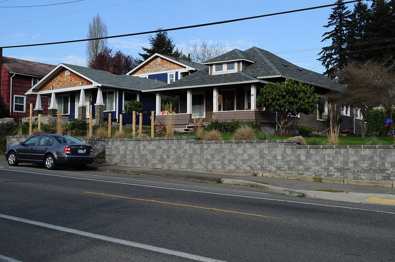 Olympia houses on NE Puget Street under a tall canopy. Not a job still. Not John.